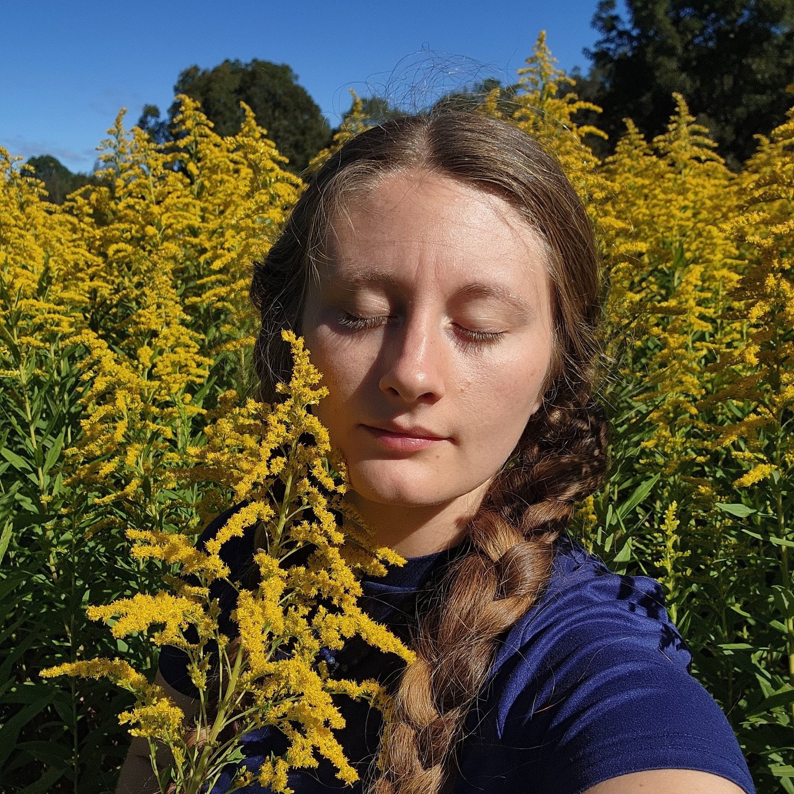 Ashley, owner of Zenquility Cleaning Services, in a field of goldenrod near Athens, GA
